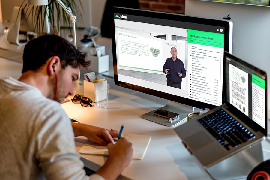 Man watching an Mpirical course on his computer while making notes