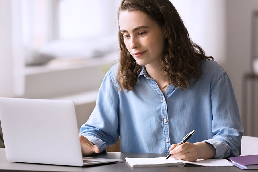 A woman looking at their laptop with Mpirical training