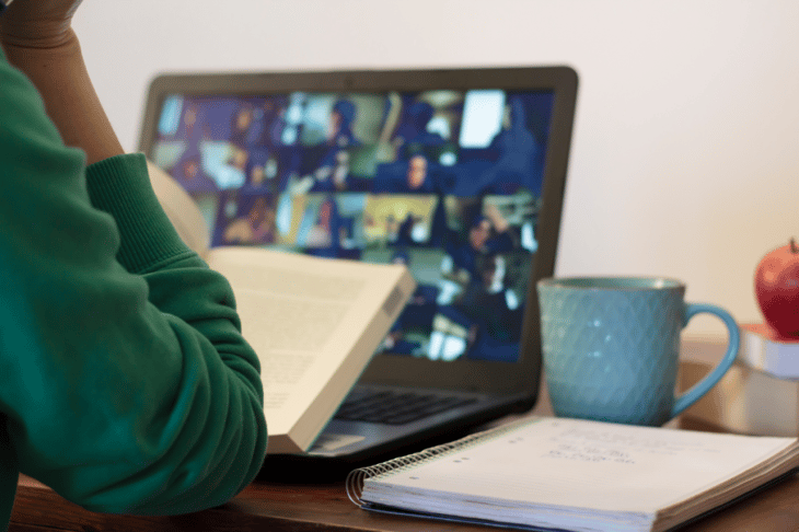 woman sitting at desk with laptop open to an online classroom