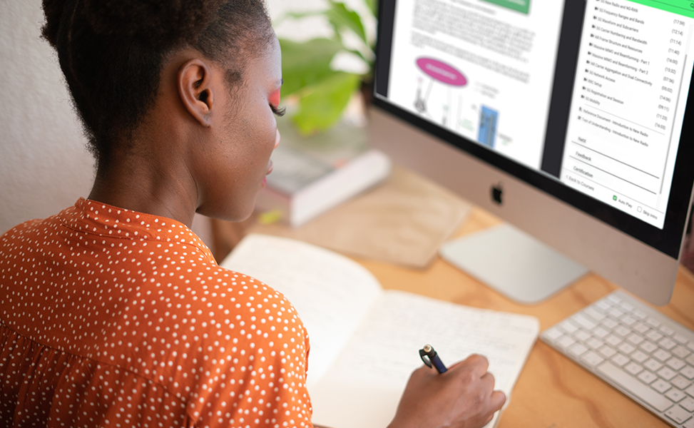 Woman taking notes while reading a course reference document on the Mpirical learning platform
