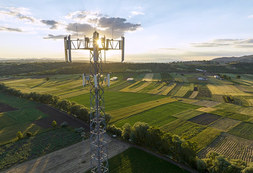 Telecoms antenna at height overlooking fields at sunset