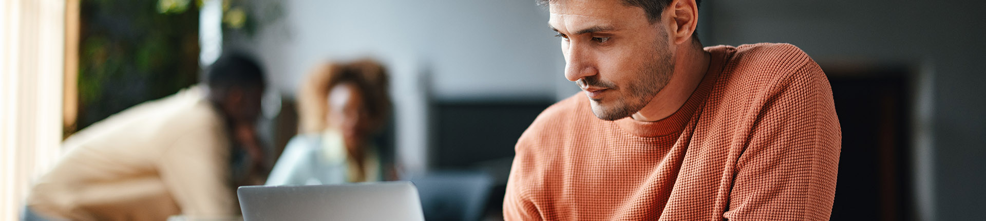 Downloads header - man looking at laptop
