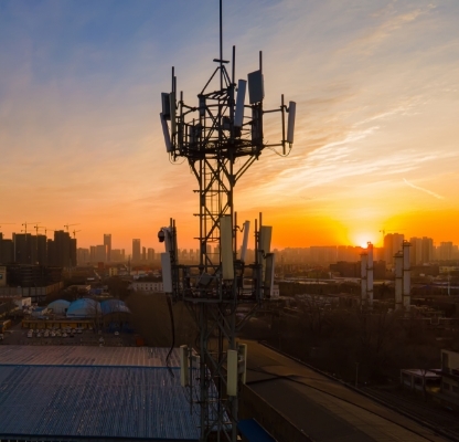 Unlimited Access Package - Telecoms antenna at height over city at sunrise
