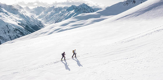 two people hiking up a snowy mountain