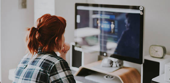 girl in checked shirt looking at computer screen
