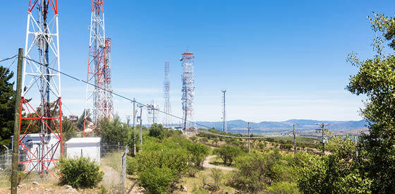 skyline with radio towers on a green hill
