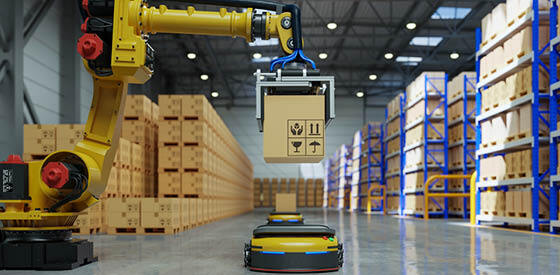 yellow robot arm loading a box in a factory