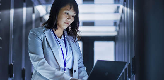 woman in blue shirt looking at laptop
