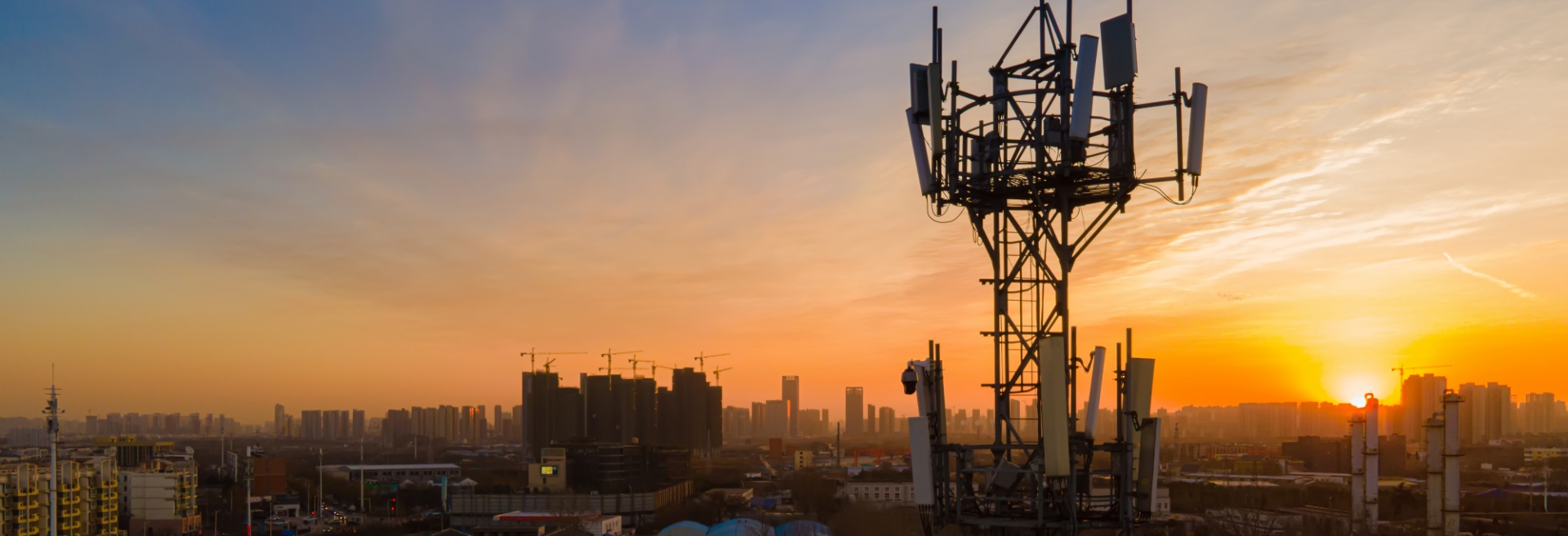 Telecoms Antenna over a city at sunrise